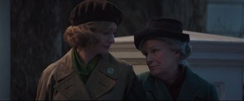 Movie still from “Mary Poppins Returns” (2018), directed by Rob Marshall – Two older women wearing hats and jackets; Close Up shot, Over the shoulder angle