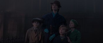Movie still from “Mary Poppins Returns” (2018), directed by Rob Marshall – A group of people standing next to each other in the dark; Medium shot, Low angle