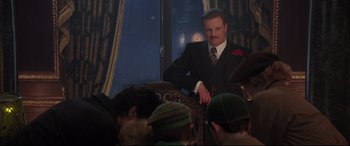 Movie still from “Mary Poppins Returns” (2018), directed by Rob Marshall – A man in a suit and tie standing in front of a window; Medium shot, Over the shoulder angle