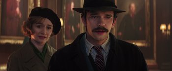 Movie still from “Mary Poppins Returns” (2018), directed by Rob Marshall – A man with a mustache wearing a hat and a suit; Close Up shot, Over the shoulder angle