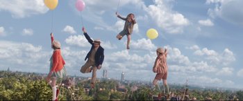 Movie still from “Mary Poppins Returns” (2018), directed by Rob Marshall – A group of people flying through the air holding balloons; Wide shot, Low angle