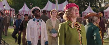 Movie still from “Mary Poppins Returns” (2018), directed by Rob Marshall – A group of people standing in front of a tent; Medium shot, Over the shoulder angle