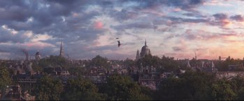 Movie still from “Mary Poppins Returns” (2018), directed by Rob Marshall – A helicopter flying over a city with a building in the background; Extreme Wide shot, High angle