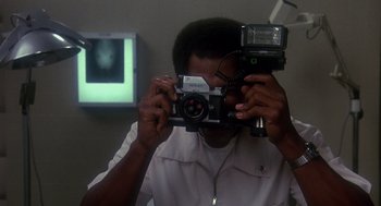 Movie still from “Mask” (1985), directed by Peter Bogdanovich – A man taking a picture of himself with a camera; Close Up shot, Low angle
