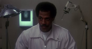 Movie still from “Mask” (1985), directed by Peter Bogdanovich – A man in a white shirt is looking at the camera; Close Up shot, Low angle