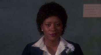 Movie still from “Mask” (1985), directed by Peter Bogdanovich – A black woman with curly hair wearing a suit; Close Up shot, Low angle