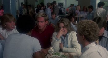 Movie still from “Mask” (1985), directed by Peter Bogdanovich – A group of people sitting at a table with food on it; Medium shot, Over the shoulder angle