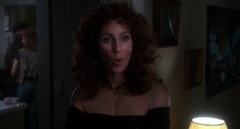 Movie still from “Mask” (1985), directed by Peter Bogdanovich – A woman in a black dress with curly red hair; Close Up shot, Over the shoulder angle