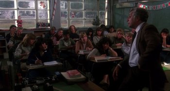 Movie still from “Mask” (1985), directed by Peter Bogdanovich – A group of people sitting in a classroom with books; Medium shot, High angle