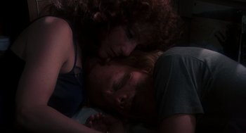 Movie still from “Mask” (1985), directed by Peter Bogdanovich – A man and a woman laying on the ground; Close Up shot, Overhead angle
