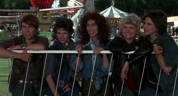 Movie still from “Mask” (1985), directed by Peter Bogdanovich – A group of women standing next to each other at an amusement park; Medium shot, Low angle