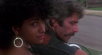 Movie still from “Mask” (1985), directed by Peter Bogdanovich – A man and a woman sitting next to each other; Close Up shot, Over the shoulder angle