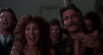 Movie still from “Mask” (1985), directed by Peter Bogdanovich – A group of people that are standing in a room together; Close Up shot, Low angle