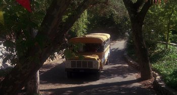 Movie still from “Mask” (1985), directed by Peter Bogdanovich – An old yellow school bus driving down the street; Extreme Wide shot, High angle
