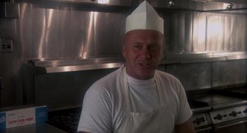 Movie still from “Mask” (1985), directed by Peter Bogdanovich – A man wearing a chef's hat in a kitchen; Close Up shot, Low angle