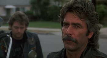 Movie still from “Mask” (1985), directed by Peter Bogdanovich – A person with a mustache; Close Up shot, Over the shoulder angle