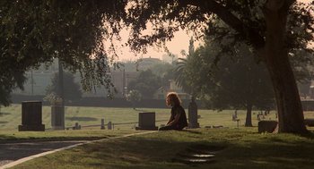Movie still from “Mask” (1985), directed by Peter Bogdanovich – A woman sitting on the ground with a laptop in her lap; Wide shot, High angle