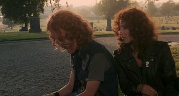 Movie still from “Mask” (1985), directed by Peter Bogdanovich – A couple of people that are sitting on a bike; Medium shot, Over the shoulder angle