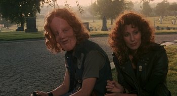 Movie still from “Mask” (1985), directed by Peter Bogdanovich – A man and a woman sitting next to each other; Close Up shot, Low angle