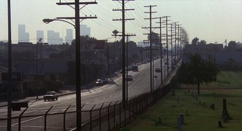 Movie still from “Mask” (1985), directed by Peter Bogdanovich – A view of an empty street with power lines overhead; Extreme Wide shot, High angle