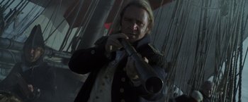 Movie still from “Master and Commander: The Far Side of the World” (2003), directed by Peter Weir – A man holding a telescope in front of a ship; Close Up shot, Over the shoulder angle