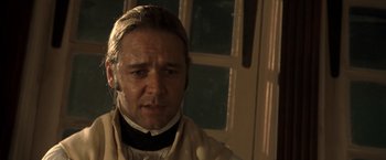 Movie still from “Master and Commander: The Far Side of the World” (2003), directed by Peter Weir – A person wearing a suit and tie; Close Up shot, Over the shoulder angle