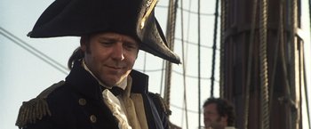 Movie still from “Master and Commander: The Far Side of the World” (2003), directed by Peter Weir – A person wearing a pirate hat; Close Up shot, Over the shoulder angle