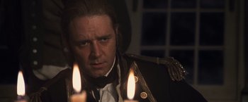 Movie still from “Master and Commander: The Far Side of the World” (2003), directed by Peter Weir – A person wearing a suit and tie; Close Up shot, Over the shoulder angle