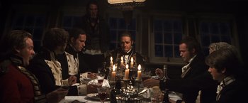 Movie still from “Master and Commander: The Far Side of the World” (2003), directed by Peter Weir – A group of men sitting around a dinner table; Medium shot, Over the shoulder angle