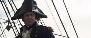 Movie still from “Master and Commander: The Far Side of the World” (2003), directed by Peter Weir – A person wearing a hat on a boat; Close Up shot, Low angle