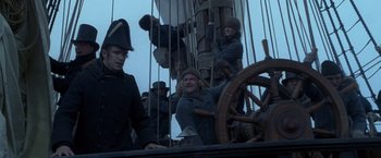 Movie still from “Master and Commander: The Far Side of the World” (2003), directed by Peter Weir – A group of people standing on top of a boat; Medium shot, Low angle