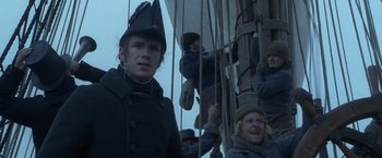 Movie still from “Master and Commander: The Far Side of the World” (2003), directed by Peter Weir – A group of people on a boat in the water; Medium shot, Low angle