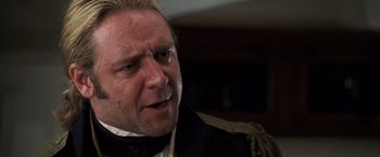 Movie still from “Master and Commander: The Far Side of the World” (2003), directed by Peter Weir – A person wearing a suit and tie; Close Up shot, Over the shoulder angle