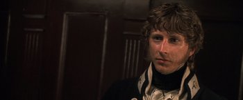 Movie still from “Master and Commander: The Far Side of the World” (2003), directed by Peter Weir – A young man with curly brown hair wearing a black jacket; Close Up shot, Over the shoulder angle