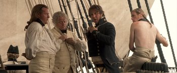 Movie still from “Master and Commander: The Far Side of the World” (2003), directed by Peter Weir – Two men standing next to each other on a boat; Medium shot, Over the shoulder angle