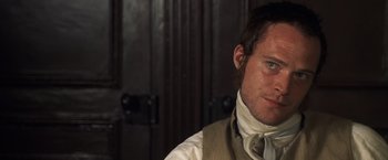 Movie still from “Master and Commander: The Far Side of the World” (2003), directed by Peter Weir – A person wearing a suit and tie; Close Up shot, Over the shoulder angle
