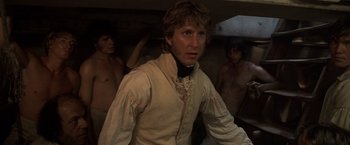 Movie still from “Master and Commander: The Far Side of the World” (2003), directed by Peter Weir – A man wearing a white shirt and a black shirt; Medium shot, Low angle