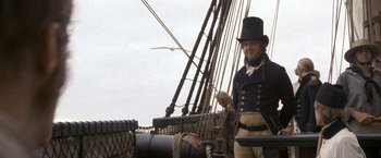 Movie still from “Master and Commander: The Far Side of the World” (2003), directed by Peter Weir – A man standing on top of a boat in front of a bird; Medium shot, Low angle