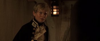 Movie still from “Master and Commander: The Far Side of the World” (2003), directed by Peter Weir – A young boy dressed in a military uniform; Close Up shot, High angle
