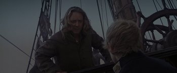 Movie still from “Master and Commander: The Far Side of the World” (2003), directed by Peter Weir – A man standing next to another man in a boat; Medium shot, Over the shoulder angle