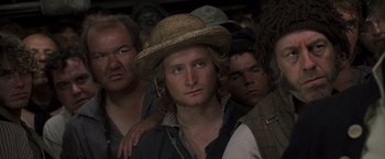 Movie still from “Master and Commander: The Far Side of the World” (2003), directed by Peter Weir – A group of men standing next to each other wearing hats; Close Up shot, High angle