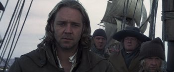 Movie still from “Master and Commander: The Far Side of the World” (2003), directed by Peter Weir – A group of men standing next to each other on top of a hill; Close Up shot, Over the shoulder angle