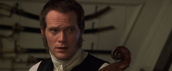 Movie still from “Master and Commander: The Far Side of the World” (2003), directed by Peter Weir – A person with a violin; Close Up shot, Over the shoulder angle