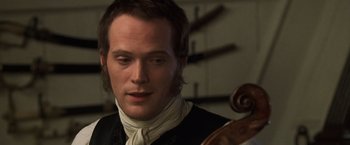 Movie still from “Master and Commander: The Far Side of the World” (2003), directed by Peter Weir – A person holding a violin; Close Up shot, Over the shoulder angle