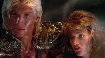 Movie still from “Masters of the Universe” (1987), directed by Gary Goddard – A man and a woman wearing a helmet and armor; Close Up shot, Low angle