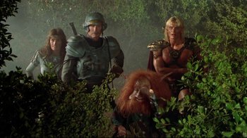 Movie still from “Masters of the Universe” (1987), directed by Gary Goddard – A group of men in costume in a forest; Wide shot, Low angle