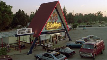 Movie still from “Masters of the Universe” (1987), directed by Gary Goddard – A building that has a neon sign on top of it; Extreme Wide shot, High angle