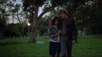 Movie still from “Masters of the Universe” (1987), directed by Gary Goddard – A man and a woman are walking in a cemetery; Medium shot, Low angle