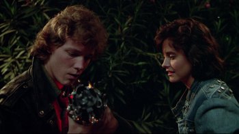Movie still from “Masters of the Universe” (1987), directed by Gary Goddard – A man and a woman are holding a candle; Close Up shot, Over the shoulder angle
