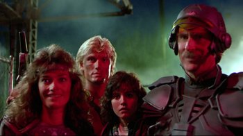 Movie still from “Masters of the Universe” (1987), directed by Gary Goddard – A group of people standing next to each other in a room; Medium shot, Low angle